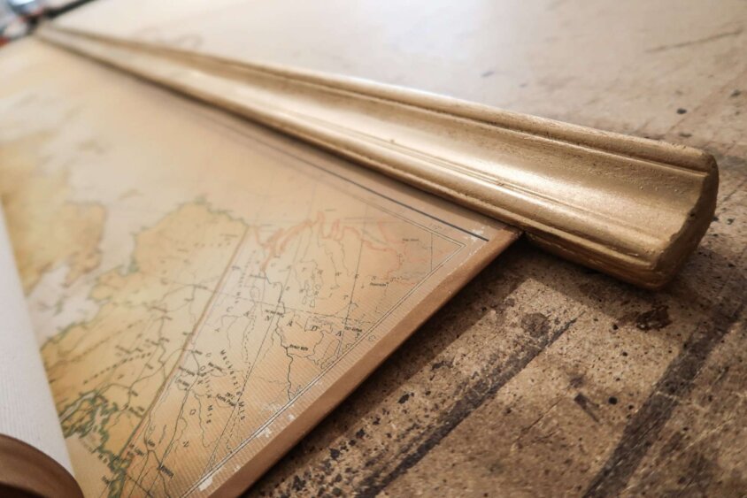 Chic map of the world with golden edges on workbench
